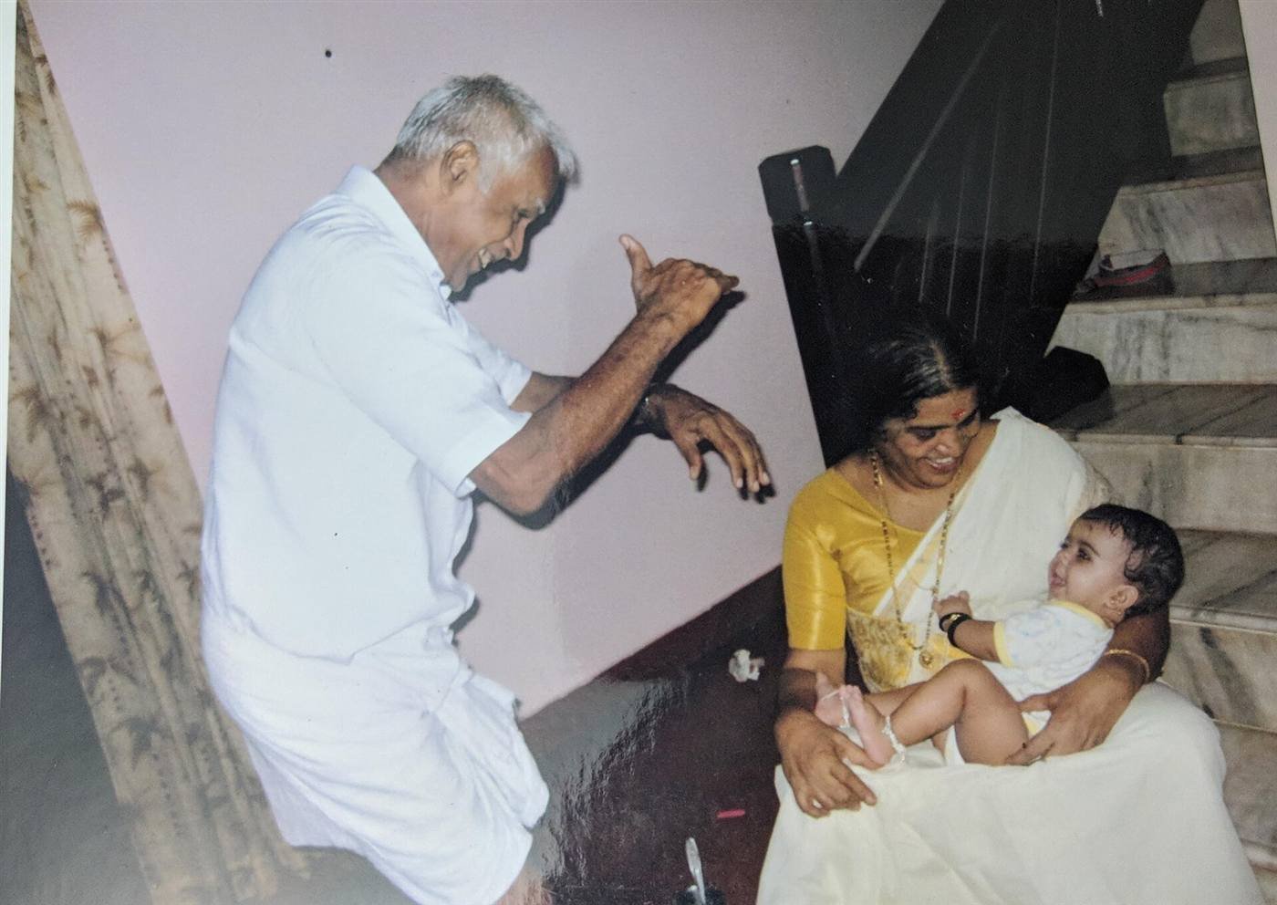 A grandfather, grandmother and their grandchild sharing a joyful moment together